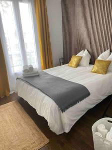 Cette chambre d'hôtel comprend 2 lits avec des oreillers jaunes. dans l'établissement Comme à la maison-Porte de Paris, à Pantin