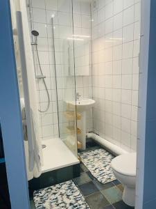 La salle de bains est pourvue d'une douche, de toilettes et d'un lavabo. dans l'établissement Comme à la maison-Porte de Paris, à Pantin