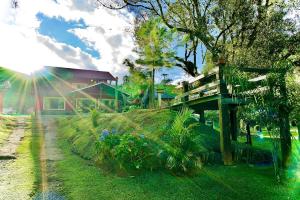 una casa con un puente de madera en un patio en Pousada Recanto dos Pássaros, en Visconde De Maua