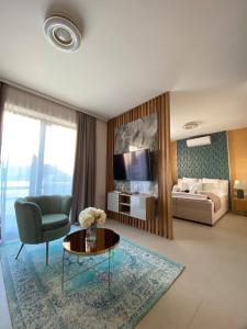 sala de estar con sofá, mesa y cama en CasaBlanca vendégház en Abádszalók