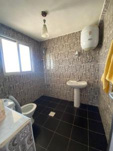 a bathroom with a toilet and a sink at Simple home in Madaba