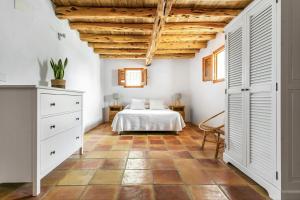 a bedroom with a bed and a wooden ceiling at CAN FERRER Authentic payesa house in San Antonio