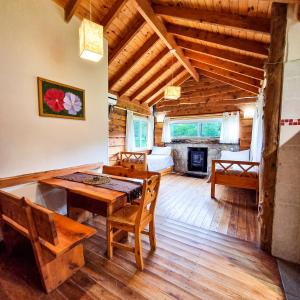 a dining room with a table and a fireplace at Cabañas del Espinillo in Villa General Belgrano