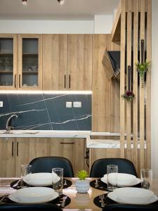 une table avec des chaises et une cuisine avec des placards en bois dans l'établissement Colourful Apartment for 4 Guests and Free Parking, à Stara Zagora