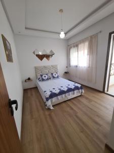 1 dormitorio con 1 cama y suelo de madera en Appartement Studio meublé à Mohammedia, en Mohammedia