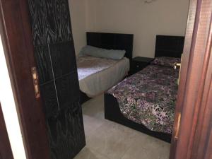 1 dormitorio pequeño con 2 camas y puerta en Stella highets, en El Alamein
