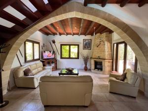 a living room with two couches and a stone fireplace at Valencia Grove Villa in Miliou