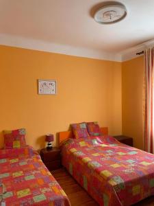 2 camas en una habitación con paredes amarillas en Habitaciónes Privadas en Hendaye "Daniela", à 5 minutes de la gare d'Hendaye et Euskotren, Wi-Fi en Hendaya