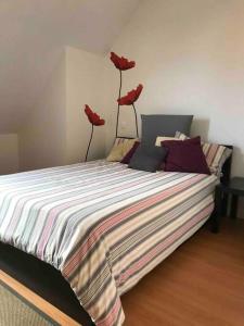 ein Schlafzimmer mit einem Bett mit drei roten Blumen drauf in der Unterkunft Precioso Ático con parking privado. Vistas al Río in Limpias