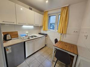 Una pequeña cocina con un fregadero y una mesa. en Przytulny Apartament w centrum, en Szczecin