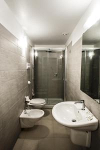 a bathroom with a toilet and a sink and a shower at Opera Suite in Castellammare del Golfo