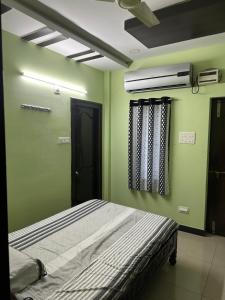 a bedroom with a bed with green walls and a ceiling at Sreenilayam Luxury Stay Homes in Rājahmundry