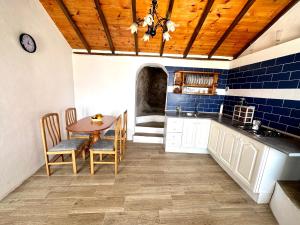 a kitchen with a wooden ceiling and a table and chairs at Chozos Cottage by VV Canary Ocean Homes in Las Cruces