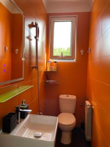 baño de color naranja con aseo y lavamanos en Habitaciónes Privadas en Hendaye "Daniela", à 5 minutes de la gare d'Hendaye et Euskotren, Wi-Fi en Hendaya
