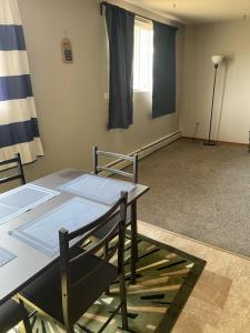 a room with a table and chairs and a window at One Bedroom Main floor Apartment in Camrose