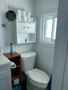 baño blanco con aseo y ventana en Hay Bay Hideaway 