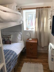 a small bedroom with a bunk bed and a window at The Blue Porch Staithes in Staithes