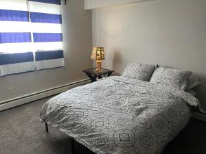 a bedroom with a bed with a lamp and a window at One Bedroom Main floor Apartment in Camrose