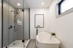 een badkamer met een douche en een bad bij Walk to Downtown Picton, 4-bedroom in Picton