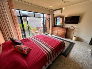een slaapkamer met een rood bed en een groot raam bij Casa de las Palmas Guest House in Oaxaca City +40 foto's