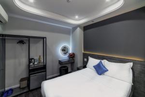 sypialnia z białym łóżkiem i niebieską poduszką w obiekcie Ruby Saigon Hotel - Ben Thanh w Ho Chi Minh
