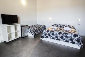 a bedroom with a bed and a flat screen tv at Opera Suite in Castellammare del Golfo