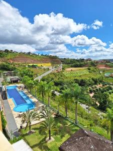 - une vue aérienne sur un complexe avec une piscine et des palmiers dans l'établissement Aconchegante apartamento studio em Bananeiras, à Bananeiras