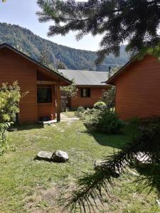 a house with a yard next to a building at Cabañas Amatista Neltume in Neltume