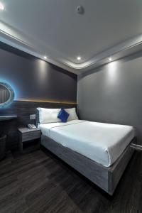 a bedroom with a large white bed with blue pillows at Ruby Saigon Hotel - Ben Thanh in Ho Chi Minh City