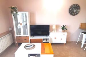 a living room with a tv and a table at Apartamento vistas al mar in Foz