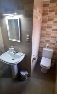 a bathroom with a sink and a toilet and a mirror at Apartamento vistas al mar in Foz
