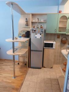 a kitchen with a refrigerator and a table in it at Green Vilnius Getaway in Vilnius