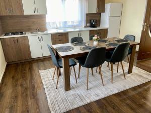 a dining room table with chairs and a kitchen at Casa Maria Platoul Luncanilor in Luncani