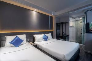 dwa łóżka siedzące obok siebie w sypialni w obiekcie Ruby Saigon Hotel - Ben Thanh w Ho Chi Minh