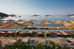 斯基亞索斯鎮的住宿－Skiathos Ammos Luxury Apartments，海滩上的一组椅子和遮阳伞