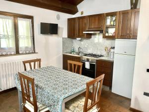 a kitchen with a table with chairs and a kitchen with a refrigerator at Appartamento Santamarcellina in San Giorgio