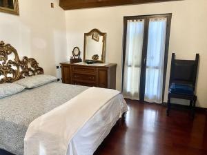 - une chambre avec un lit, une commode et un miroir dans l'établissement Appartamento Santamarcellina, à San Giorgio