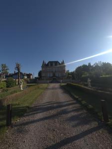 an empty road in front of a large building at Au domaine des roches in Saint-Pierre-sur-Dives +2 photos