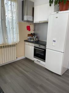 cocina con electrodomésticos blancos y nevera blanca en Habitaciónes Privadas en Hendaye "Daniela", à 5 minutes de la gare d'Hendaye et Euskotren, Wi-Fi en Hendaya