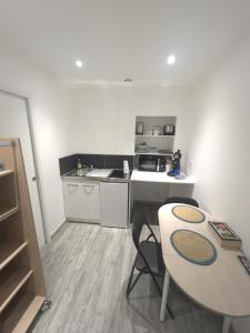 a small kitchen with a table and a counter top at Au domaine des roches in Saint-Pierre-sur-Dives
