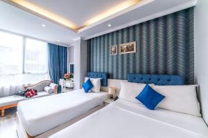2 letti in una camera d'albergo con accenti blu di Ruby Saigon Hotel - Ben Thanh ad Ho Chi Minh