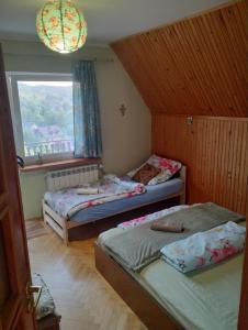 two beds in a room with a window at Nowa Jutrzenka in Stryszawa