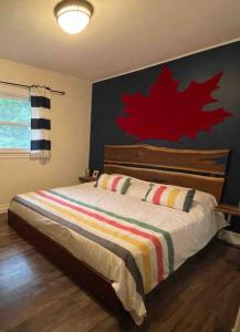 ピクトンにあるDowntown Picton, newly renovatedのベッドルーム1室(赤い絵画の壁にベッド1台付)