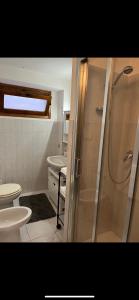 a bathroom with a shower and a toilet and a sink at Bellagio Apartment San Giovanni in Bellagio