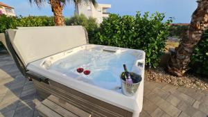 bañera de hidromasaje con botella de vino en Apartments Pool Villa Aldura, en Novalja
