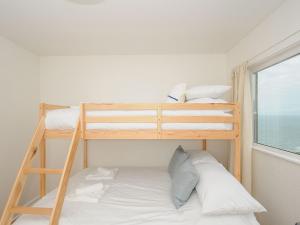 two bunk beds in a small room with a window at Westcroft 6 Withnoe Terrace in Torpoint
