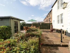 a patio with a table and an umbrella at Abbey Farm House in St Bees