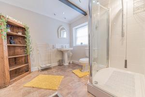 a bathroom with a shower and a toilet and a sink at Abbey Farm House in St Bees