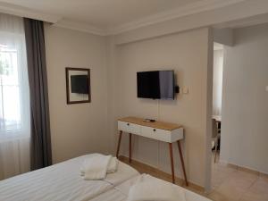 a bedroom with a bed and a tv on a wall at FA&BER Homes in Marmaris