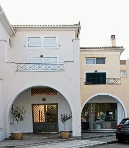 ein Haus mit zwei Bögen und einem davor geparkten Auto in der Unterkunft Hermione Port Luxury Residence in Ermioni
